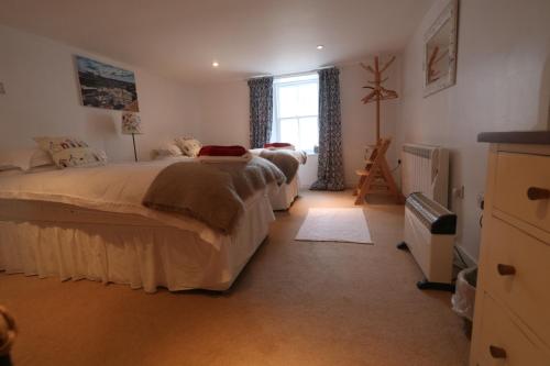 een slaapkamer met twee bedden en een raam bij Moir Cottage in Portpatrick