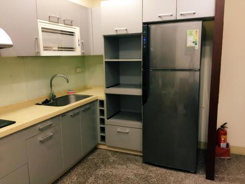 a kitchen with a black refrigerator and a sink at Fall in love Karuizawa Hostel in Puli