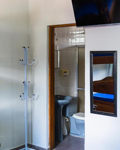 un bagno con un water, un lavandino e uno specchio di Chales sol e mar a Ubatuba