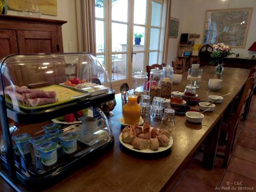 einen langen Tisch mit Essen in der Küche in der Unterkunft AU PIED DU VENTOUX in Flassan