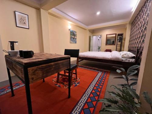 Habitación con escritorio, cama y mesa. en Spacious Traditional Room with Boudha Stupa View, en Katmandú