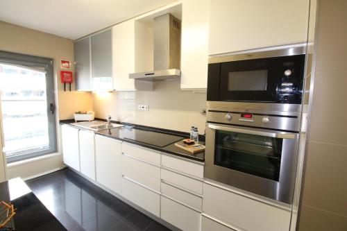 a kitchen with a stainless steel oven and a microwave at Parque das Nacoes River view ,free wifi in Lisbon