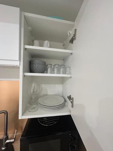 a kitchen cabinet with plates and dishes on it at Jungle house,Arr autonome,Proche Aéroport & Gare in Beauvais