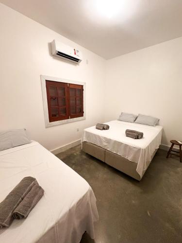 a room with two beds and a window with a window at Oásis House in Macau