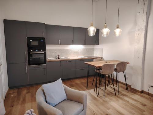 勒芒Majestueux Bouquet的厨房配有桌子、沙发和椅子