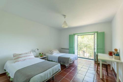 una camera da letto con due letti, una scrivania e una finestra di 188 - Quinta da Sobreda a Monte da Formiga