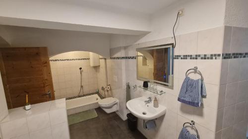 a bathroom with a sink and a toilet and a tub at Ferienwohnung Hugos Altstadt in Pirna