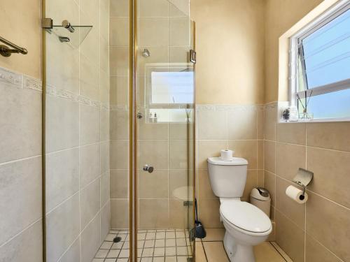 a bathroom with a toilet and a glass shower at 70 on Brander in Cape Town