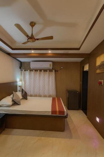 a bedroom with a bed with a ceiling fan at Ostro Inn Royal Studio Apartment Shakespeare Sarani in Kolkata