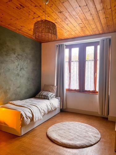 a bedroom with a bed and a large window at La Vallée d Anna in Munster