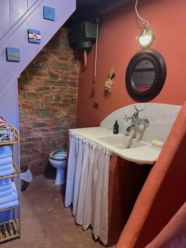 a bathroom with a sink and a stone wall at House of Thaleia in Manolátes