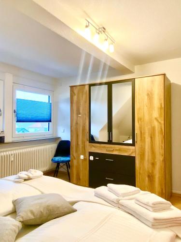 two beds in a bedroom with a large wooden cabinet at Traumhaftes Apartment mit Dachterrasse und Schlossblick in Marburg an der Lahn