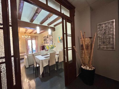 a dining room with a table and white chairs at Font 1 Circo Romano in Tarragona