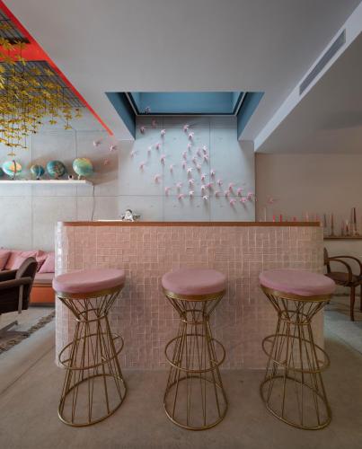three bar stools in front of a counter in a room at toctoctoc lisboa in Lisbon