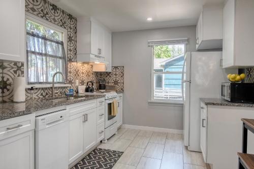 科达伦Yellow Rocker Bungalow - Feels like home!的厨房配有白色橱柜和大窗户