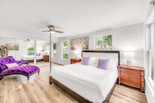 ein Schlafzimmer mit einem großen Bett und einem lila Sofa in der Unterkunft Heated Pool Las Olas Victoria Park Near Beach Escapism at its finest Mermaid Key in Fort Lauderdale