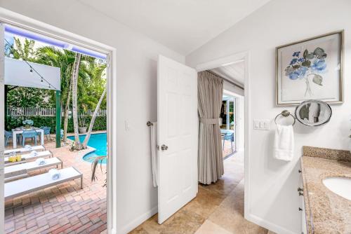 ein Bad mit einem Waschbecken und Poolblick in der Unterkunft Heated Pool Las Olas Victoria Park Near Beach Escapism at its finest Mermaid Key in Fort Lauderdale
