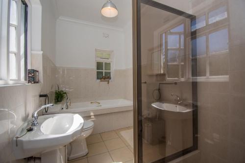 a bathroom with a sink and a toilet and a shower at Sunny Poolside Escape in Somerset West in Somerset West