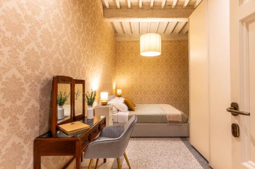 Un dormitorio con una cama, un escritorio y un espejo. en Noble Floor - Private Sauna Apartment, en Lucca