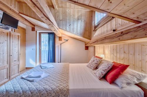 阿戈尔多Chalet Dolomiti 3 Bedrooms Parking 40 min from Cortina的卧室里有一张大床，配有红色枕头