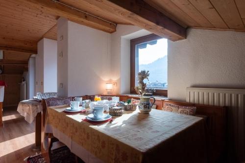 阿戈尔多Chalet Dolomiti 3 Bedrooms Parking 40 min from Cortina的带桌子和大窗户的餐厅