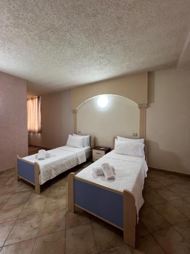 una camera d'albergo con due letti e uno specchio di Hana's Apartment a Durrës