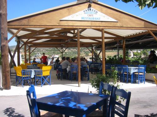 a restaurant with tables and chairs under a pavilion at Hotel Palazzo in Archangelos