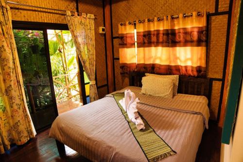 a bedroom with a bed with a baby on it at Ouychai home stay resort in Chiang Mai