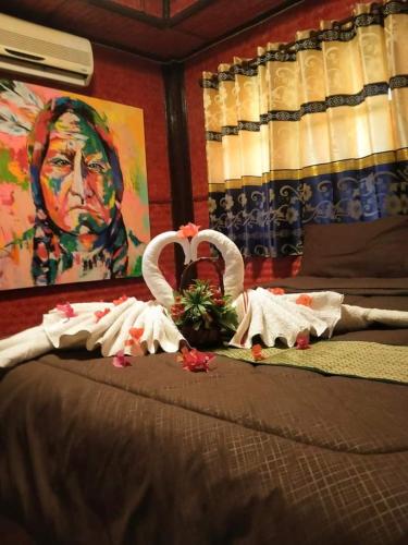a bed with towels and a painting of a man at Ouychai home stay resort in Chiang Mai