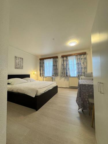 a bedroom with a bed and a table and windows at Landhotel Waldschänke in Berlin