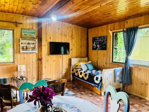 ein Schlafzimmer mit einem Bett und einem Tisch und Stühlen in der Unterkunft Casa Alma in Pucón