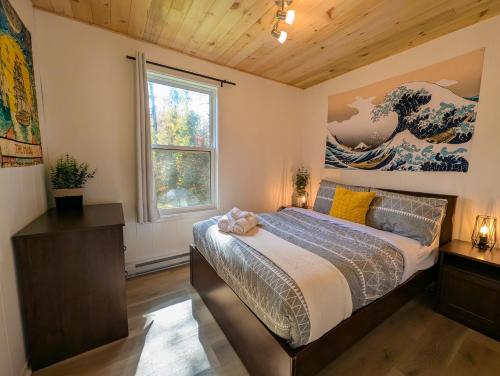 una camera da letto con un letto e una finestra di Les Refuges des Monts a Saint-Tite-des-Caps