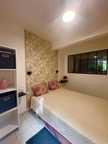 a bedroom with a bed and a window at Villa Mamalouken App Maloe in Rivière-Pilote