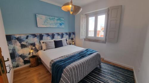 een slaapkamer met een bed en een raam erin bij Fonte do Norte in Ericeira