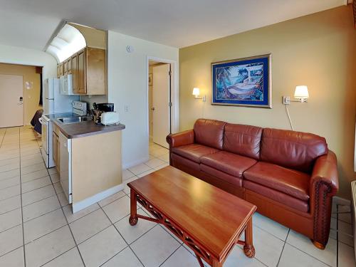 a living room with a couch and a table and a kitchen at Harbour Beach Resort 203 in Seabreeze