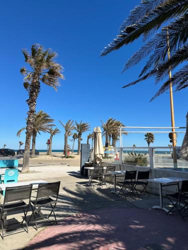 乐巴凯尔斯莱卡萨酒店的棕榈树海滩上的一组桌椅