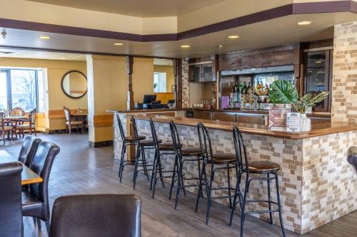 a bar in a restaurant with black stools at Prince Arthur Waterfront Hotel & Suites in Thunder Bay