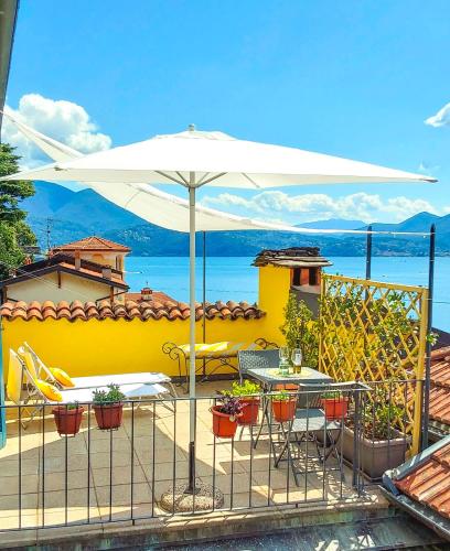 een patio met een parasol en een tafel en stoelen bij Casa Rohan in Cannero Riviera