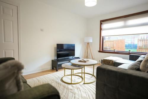 a living room with a couch and a table at Nigel House in Livingston
