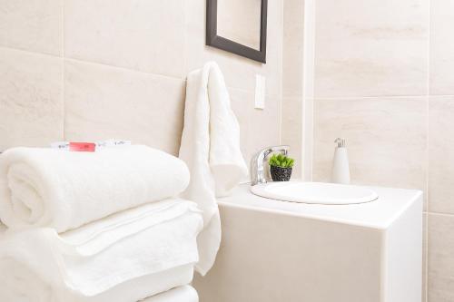 图斯潘罗德里格斯卡诺Hospedaje Aldana - Habitación ACUA zona centro的白色的浴室设有水槽和毛巾。