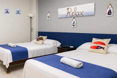 图斯潘罗德里格斯卡诺Hospedaje Aldana - Habitación ACUA zona centro的蓝白相间的房间里有两张床