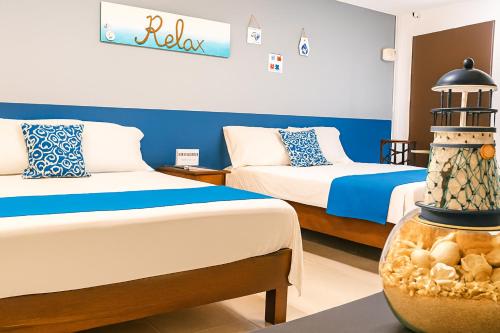 una habitación de hotel con 2 camas y un faro en Hospedaje Aldana - Habitación ACUA zona centro, en Tuxpan de Rodríguez Cano