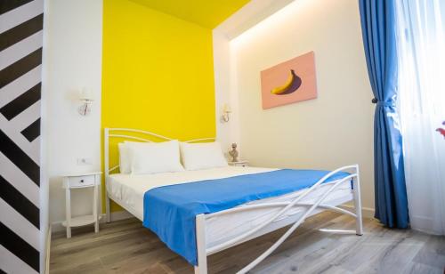 Un dormitorio con una cama con una pared azul y amarilla. en Studio Pop Art, en Batajnica
