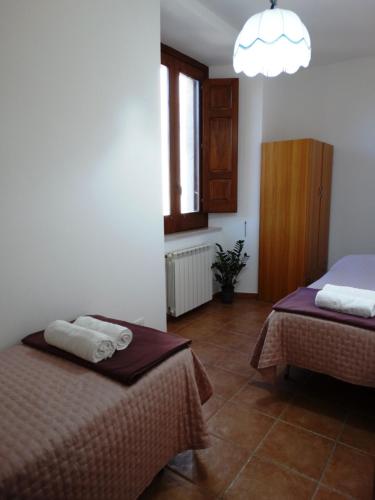 Un dormitorio con dos camas y una ventana. en Casa Daniele, en Gerace