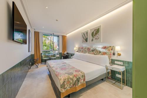 ein Hotelzimmer mit einem Bett und einem Tisch in der Unterkunft Ribera de Triana Hotel in Sevilla