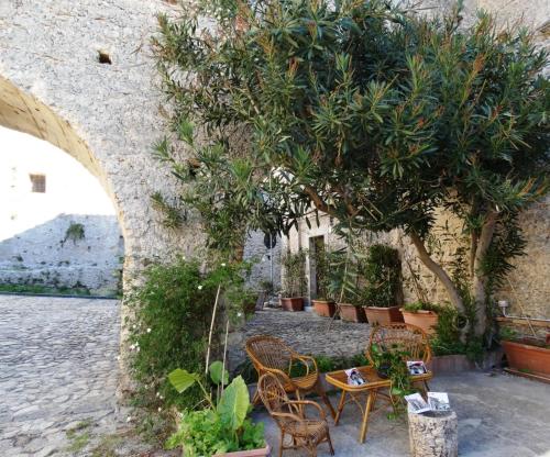 a group of chairs and tables under a tree at Casa Daniele in Gerace