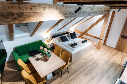 an overhead view of a living room with a green couch and a table at Apartmaji Vouk - sodobni apartmaji v objemu narave - Lukanja - Rogla - Primerno za pare in družine - Sprostitev in aktivno preživljanje prostega časa in Oplotnica