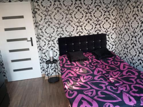 a bedroom with a bed with a purple blanket at Apartament Chopina 17 in Włocławek