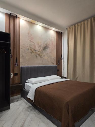 una camera da letto con un letto e un dipinto sul muro di B&B Sol Romae a Roma