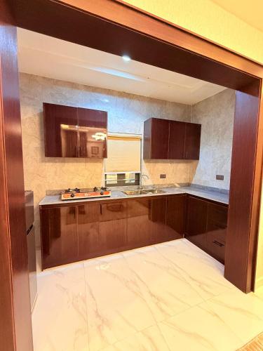 OlowoiraにあるHaven21のキッチン(茶色のキャビネット、カウンタートップ付)